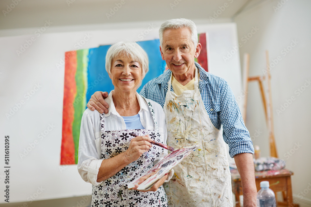 爱是激励艺术家旅程的精神。一对老年夫妇在家画画的照片。