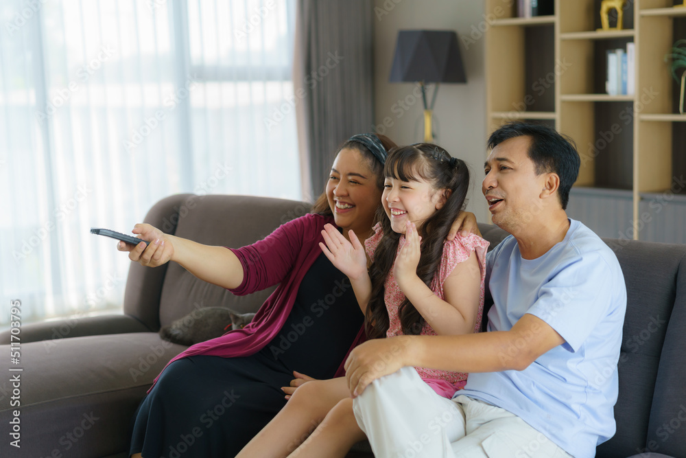 有爸爸、妈妈和女儿的快乐亚洲家庭享受周末活动，花更多时间在hom