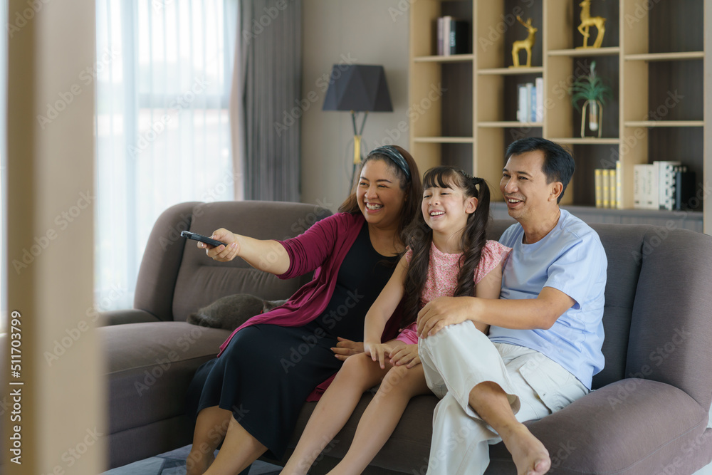 快乐的亚洲家庭与父亲、母亲和女儿一起享受周末活动，花更多时间在家里
