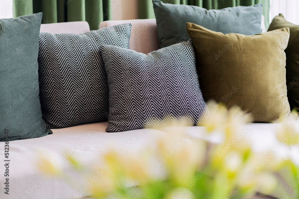 客厅的现代内饰，配有部分沙发，并在阳光明媚的日子里布置一套装饰枕头