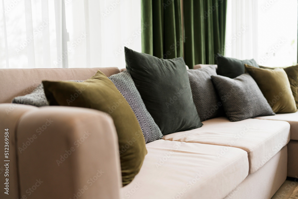 客厅的现代内饰，配有部分沙发，并在阳光明媚的日子里布置一套装饰枕头