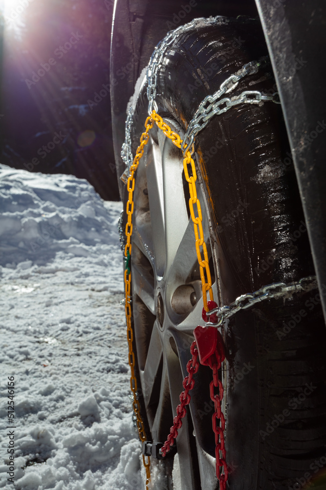Close-up image of the car wheel with winter chains for icy road