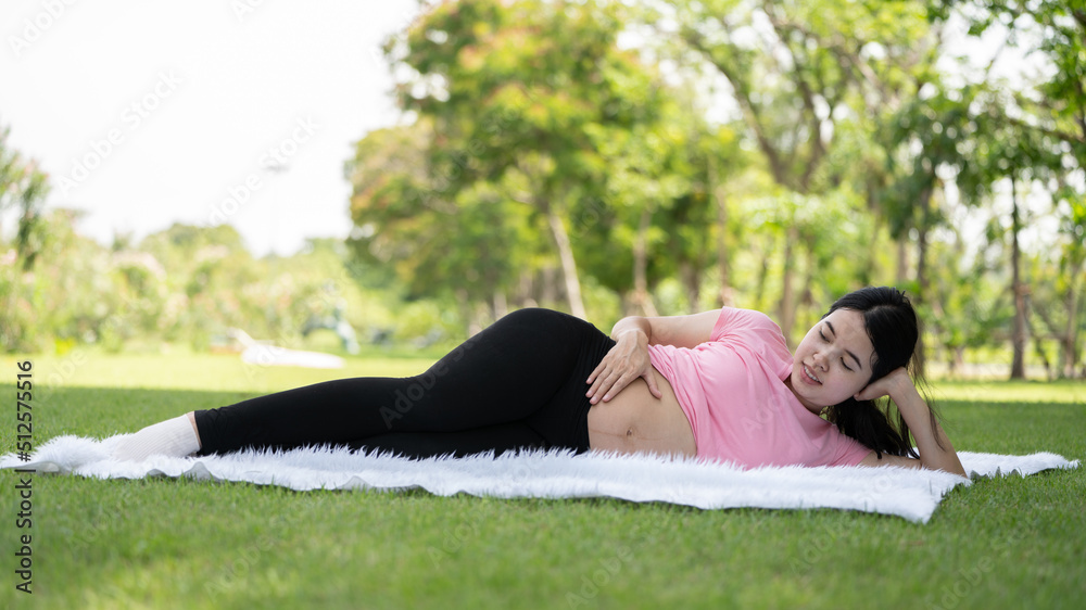 孕妇在城市公园摸肚子，孕妇放松和锻炼，美丽温柔的麋鹿