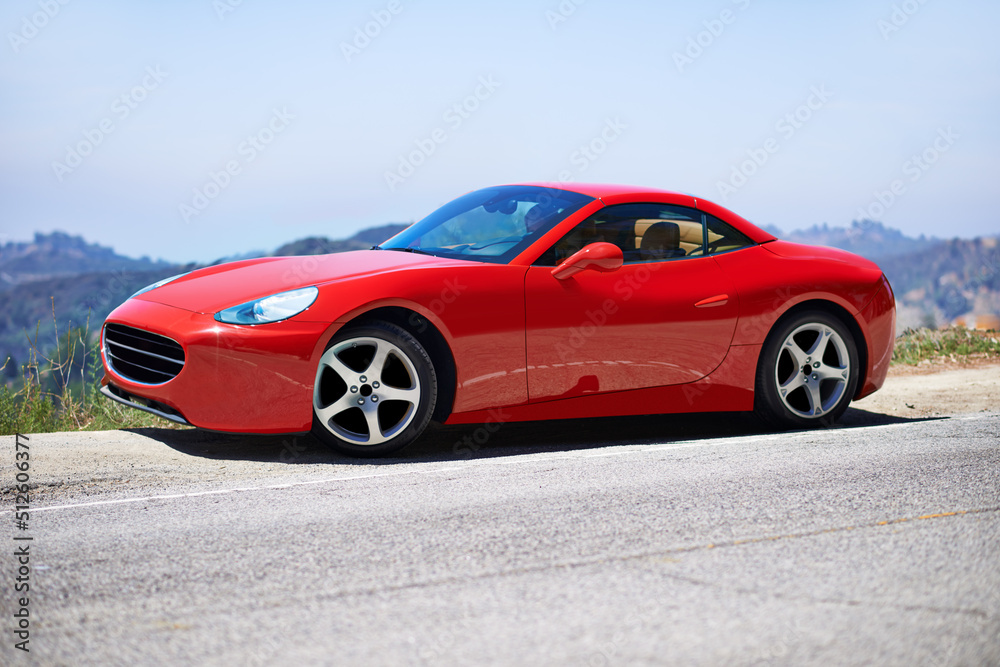 红色汽车开得更快。一名年轻女子驾驶跑车的照片。