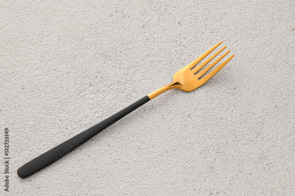 Stylish stainless steel fork on light background