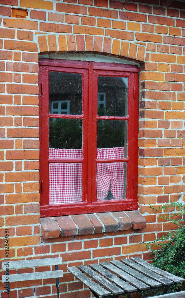 砖墙房屋或住宅的旧窗户。历史建筑上的古老红框平开窗