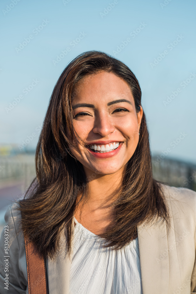 一位美丽的拉丁女子在户外日落时微笑的肖像。垂直图像