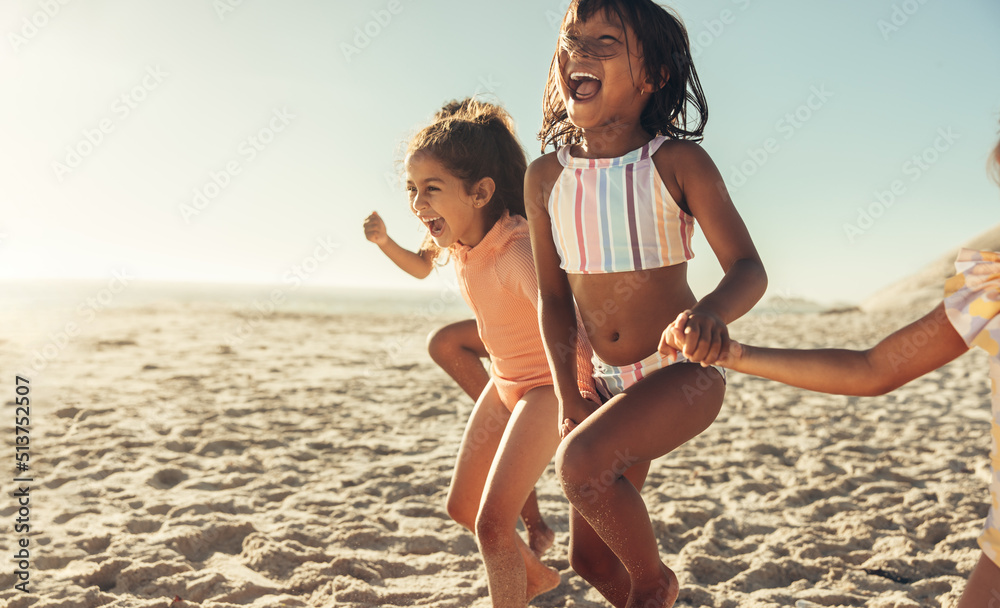 兴奋的小女孩们一起在海滩上奔跑