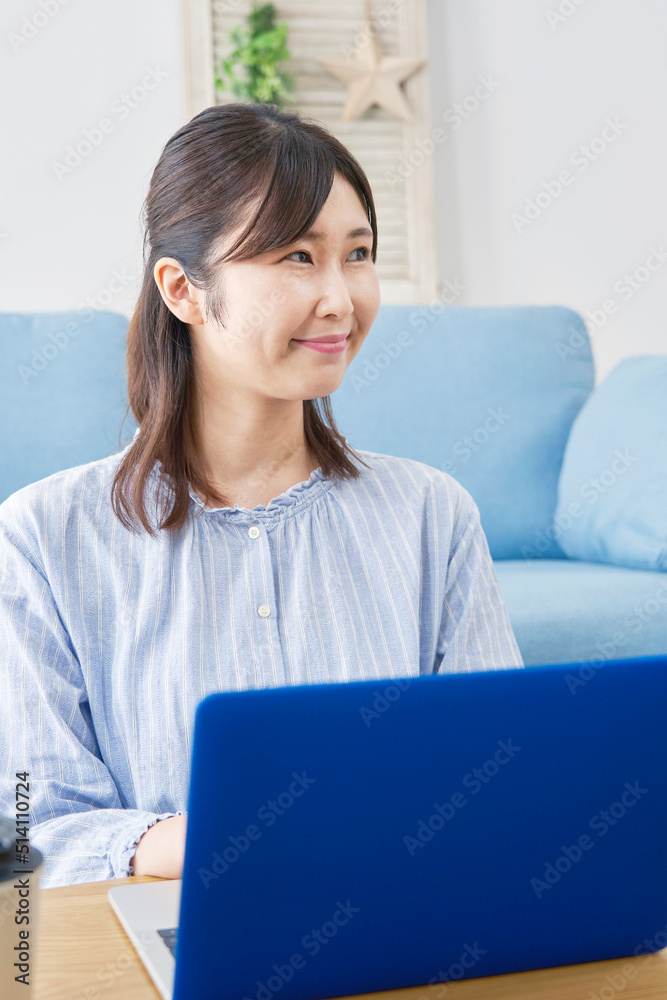 リビングでノートパソコンを使う女性