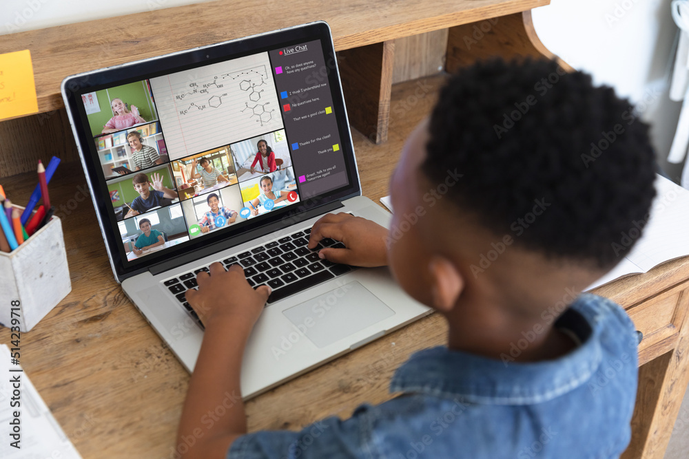 非裔美国男孩在网课学习时，在视频通话中用笔记本电脑打字
