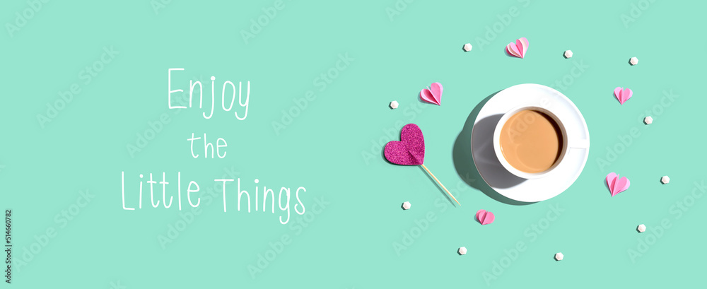 Enjoy the little things message with a cup of coffee and paper hearts - flat lay