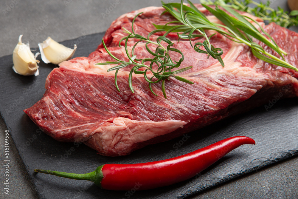 生牛排放在混凝土桌面上。健康食品概念。牛肉块和烹饪烧烤的香料