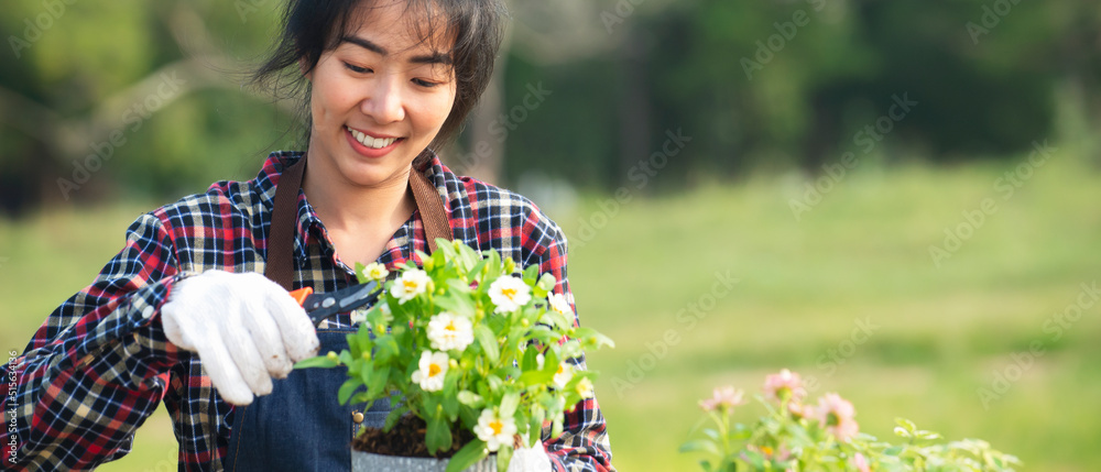 戴着手套的亚洲女子在户外剪花的肖像