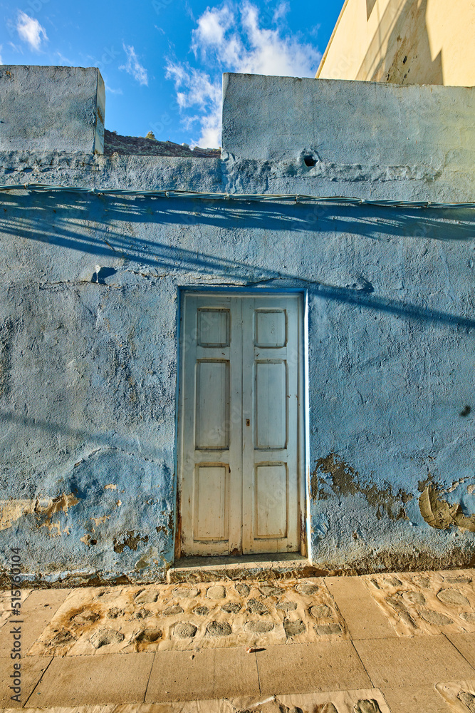 古老的废弃房屋或家，有风化的蓝色墙壁和木门。老式住宅