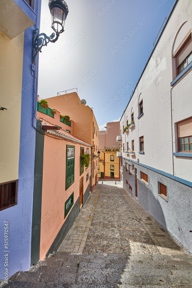 Narrow street with colorful houses and a blue sky. Architecture of tiny walk way between old townhou