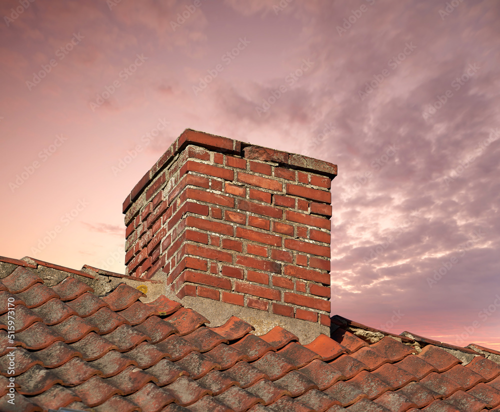 一座古老的红砖房子上的烟囱特写，天空是复制空间。一个反建筑的建筑细节