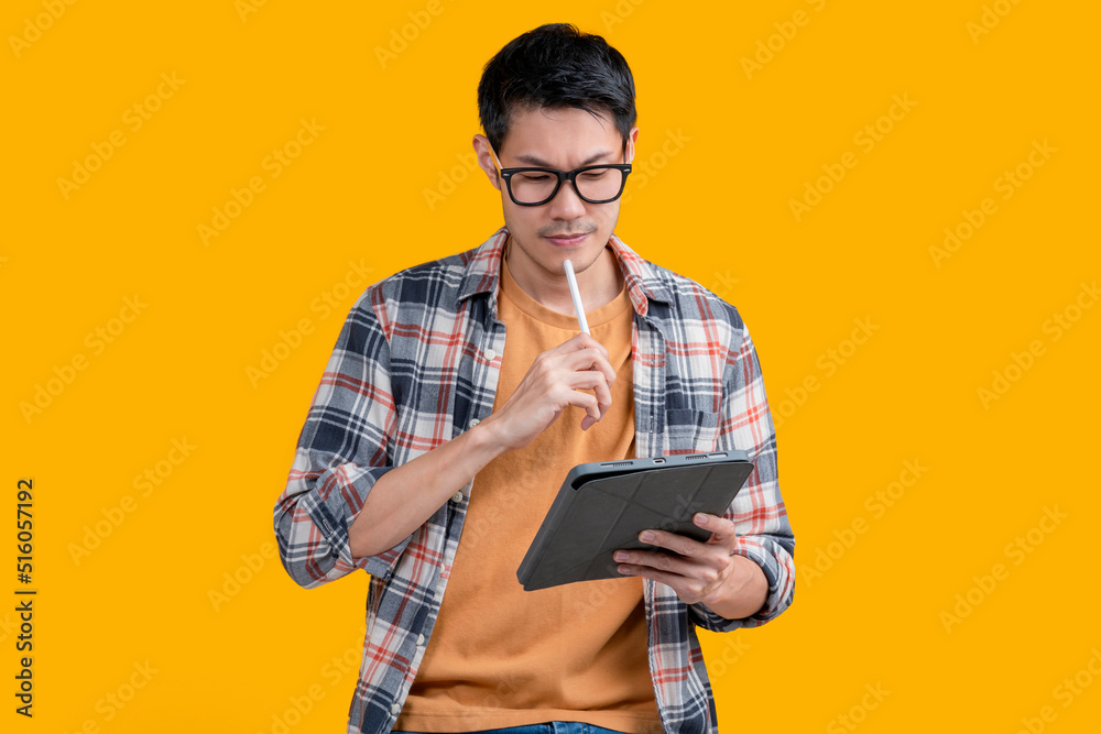 聪明的亚洲男性数字游牧自由职业者，使用数字平板电脑，有写作和指点的想法