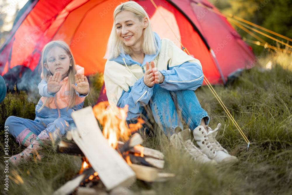 一位年轻的女士和她的小女儿坐在篝火旁，在大自然中旅行时结下了不解之缘。Mothe