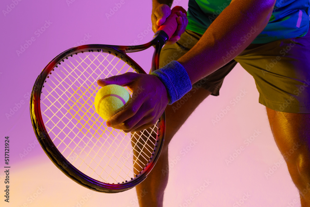 非裔美国男子网球运动员腹部在紫色和黄色霓虹灯下的图像