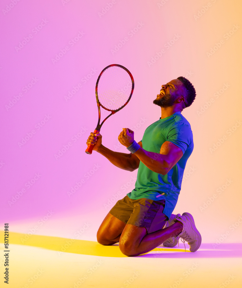 成功的非裔美国男子网球运动员在紫色和黄色灯光下的垂直图像