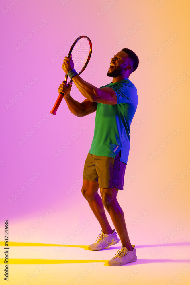 成功的非裔美国男子网球运动员在紫色和黄色灯光下的垂直图像