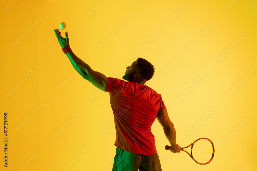 黄色灯光下快乐的非裔美国男子网球运动员形象