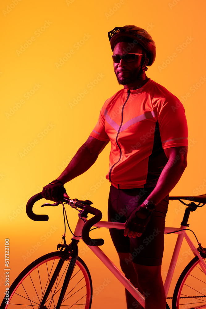 非裔美国男自行车手在黄色灯光下看着摄像机的垂直图像