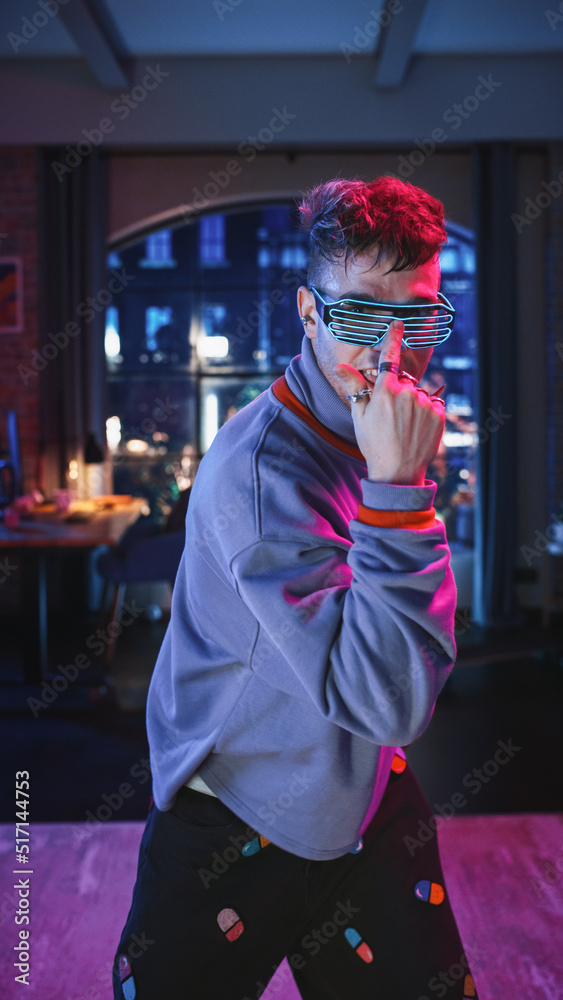 垂直屏幕：一个英俊的年轻人戴着时尚的未来主义霓虹灯发光眼镜跳舞的肖像