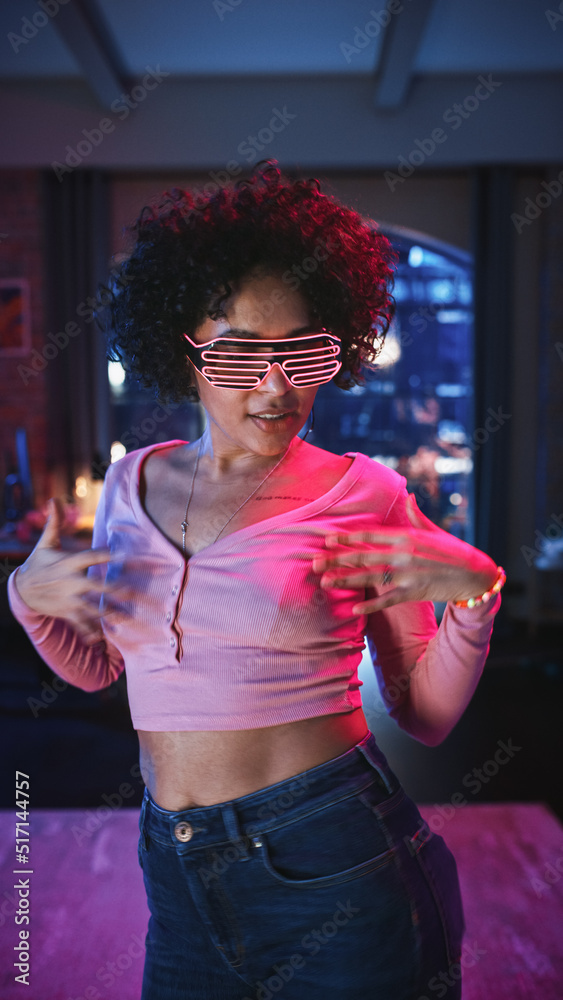 垂直屏幕：戴着未来主义霓虹灯发光眼镜跳舞的多样化年轻黑人拉丁女性，拥有