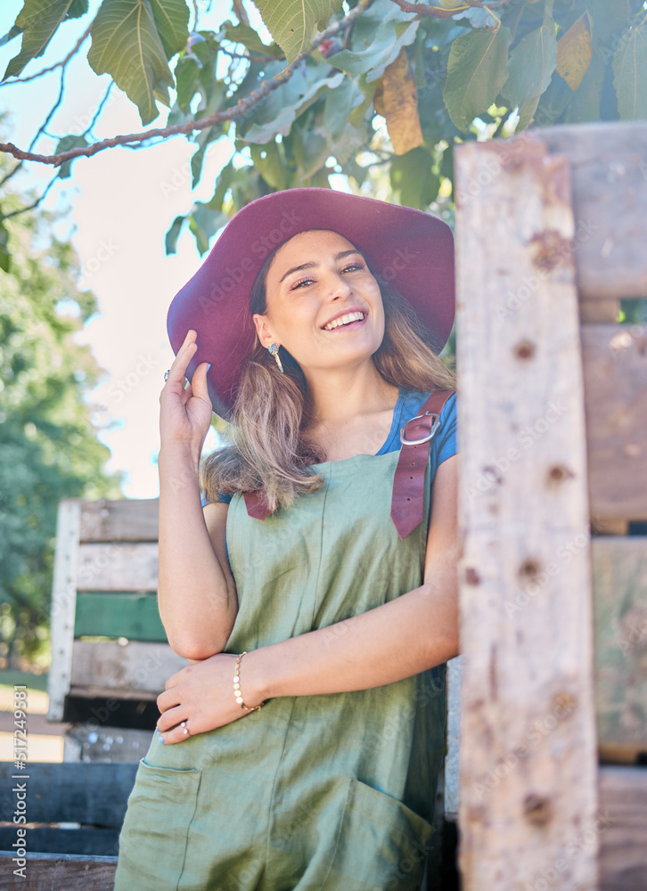 一个戴草帽的女人站在一棵树下，旁边是一个乡村的木箱。一个年轻的ha