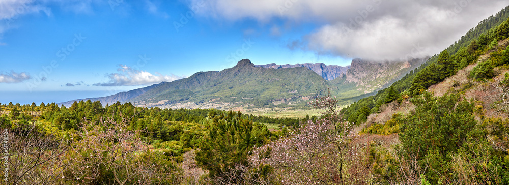 Scenic landscape of mountains in La Palma, Canary Islands, Spain against a cloudy blue sky backgroun