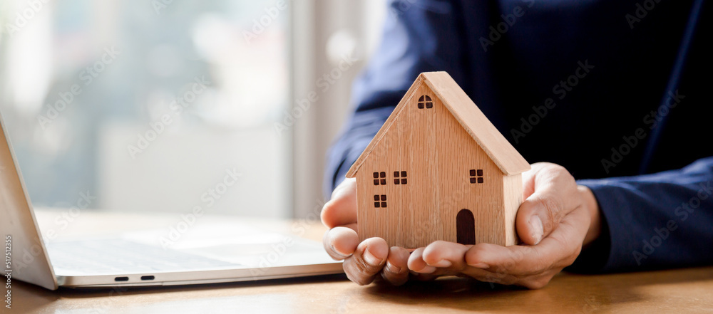 Men holding house model in hand and calculating financial chart for investment to buying property.	
