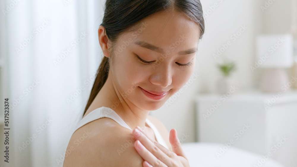 Young asian woman applying body lotion and skincare cream