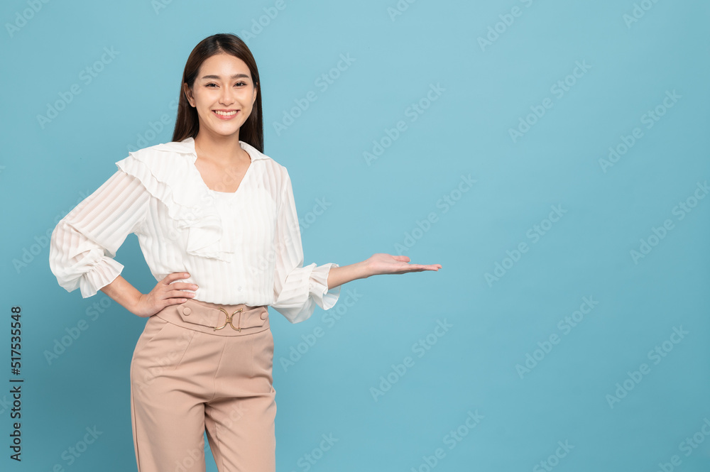 Young beautiful asian woman with smart casual cloth smiling and presenting copy space isolated on bl