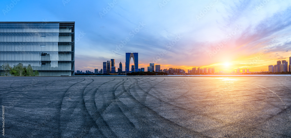 日落时分，中国苏州，沥青路面和城市天际线与现代商业建筑。