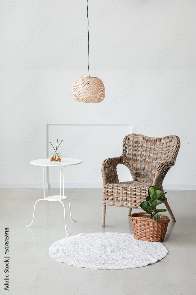 舒适的扶手椅，靠近房间的浅色墙壁，配有桌子和室内植物