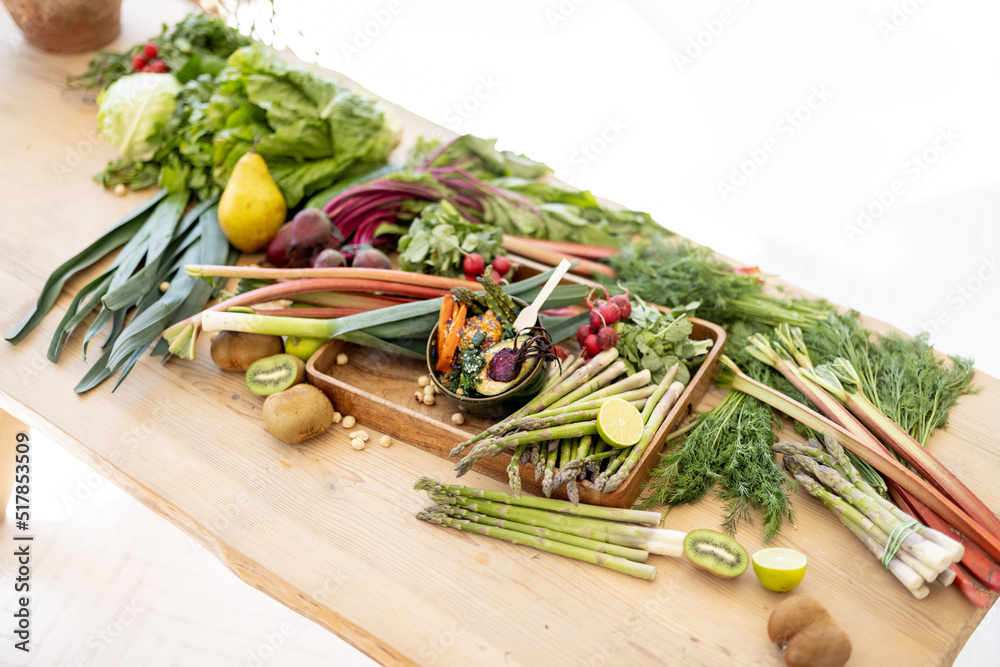 室内有很多新鲜蔬菜、水果和蔬菜的木桌。健康的纯素食生食