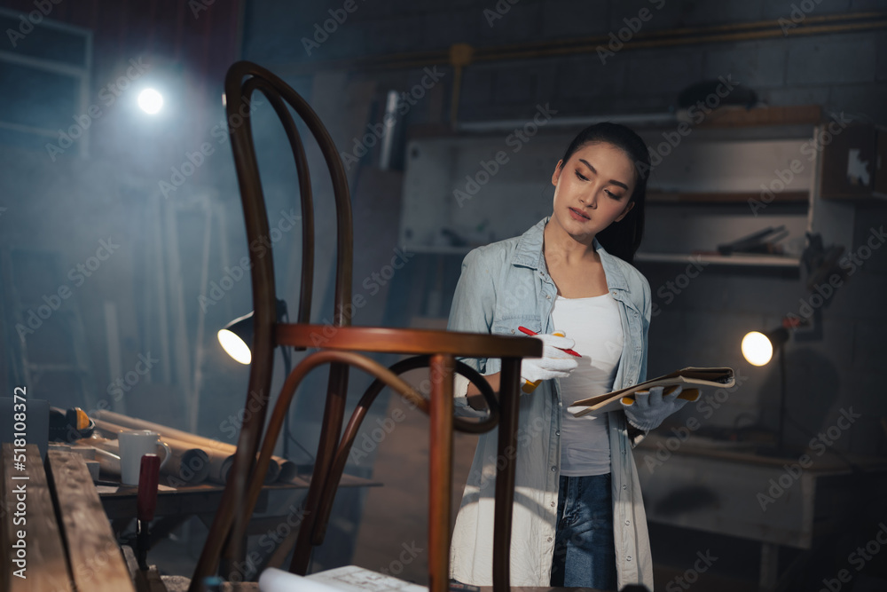 年轻的亚洲设计师家具女木匠在工作台上用卷尺测量椅子