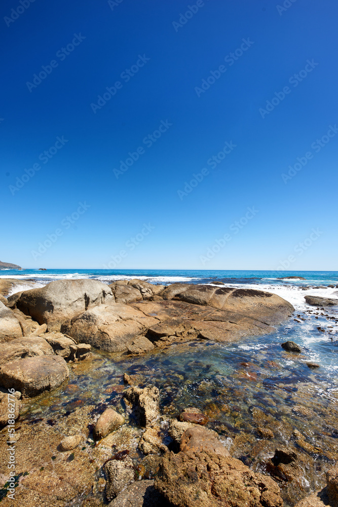 Big rocks in the ocean or sea water with a blue sky background. Beautiful landscape with a scenic vi