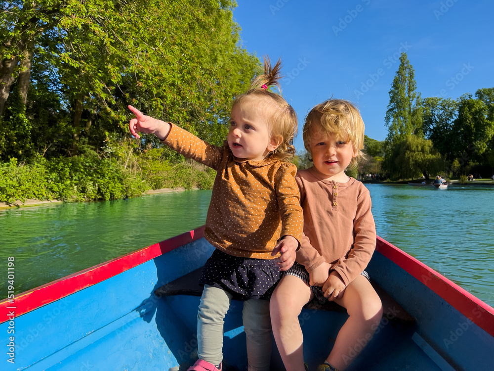 两个可爱的小孩在小桨池船上