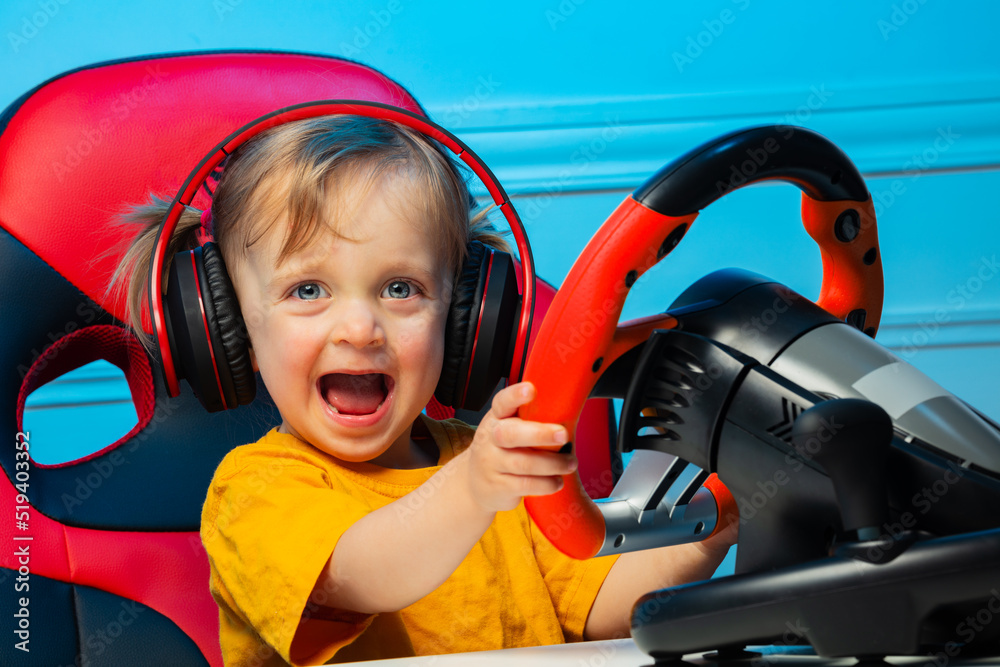 带方向盘耳机的女婴玩比赛游戏