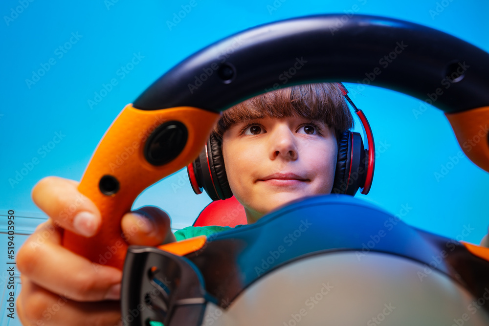 Through the steering wheel of a gamer teen boy play race game