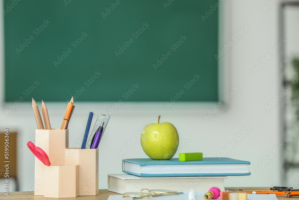 教室桌子上放着课本和文具用品的苹果