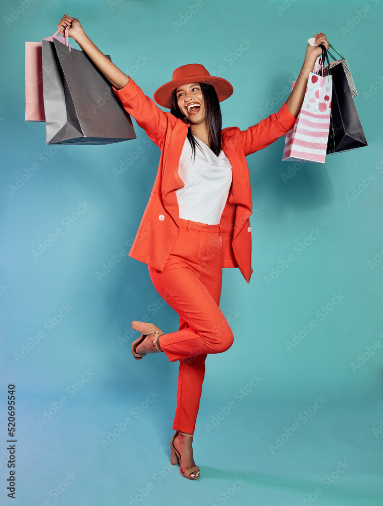 在零售疗法、消费和购买衣服后，带着购物袋的兴奋时尚女性。Styli
