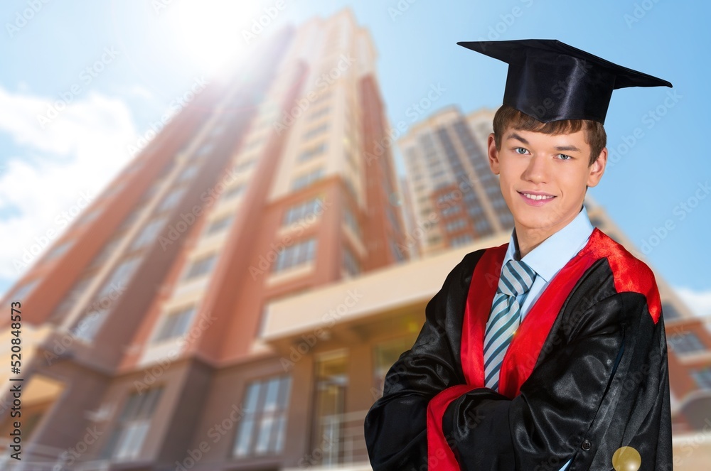 研究生男学生身穿典礼服，头戴毕业帽，男学生庆祝毕业
