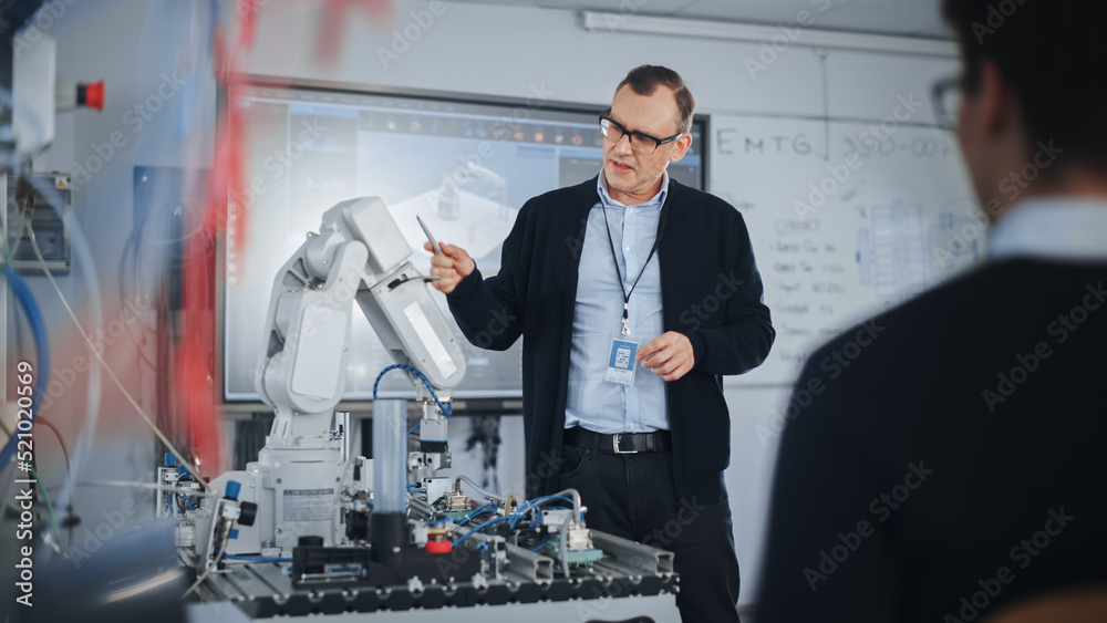 男老师在大学机器人课上与学生交谈。仿生爪在移动