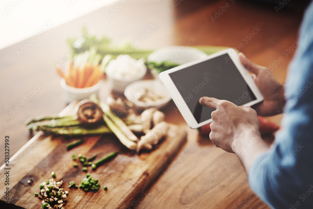 一名男子拿着平板电脑研究健康食谱，观看烹饪教程视频的特写