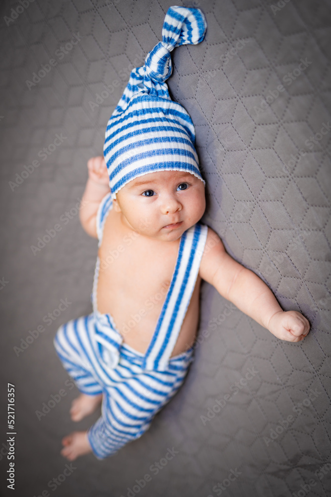 戴着滑稽帽子的小可爱婴儿。卧室里年轻可爱的新生儿。