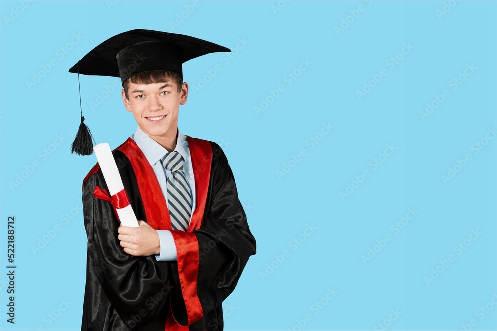 研究生男学生身穿典礼服，头戴毕业帽，手持证书。男子庆祝