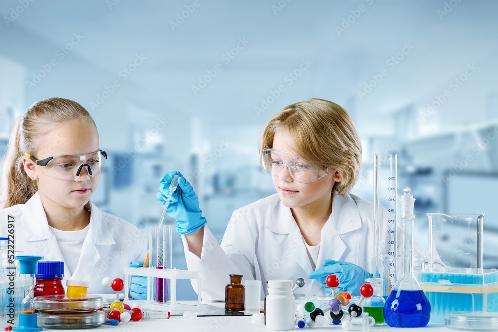 两个可爱的男孩和女孩的孩子学习科学研究并进行化学科学实验